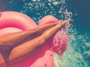 cropped image of a woman in bikini on a floatie on pool